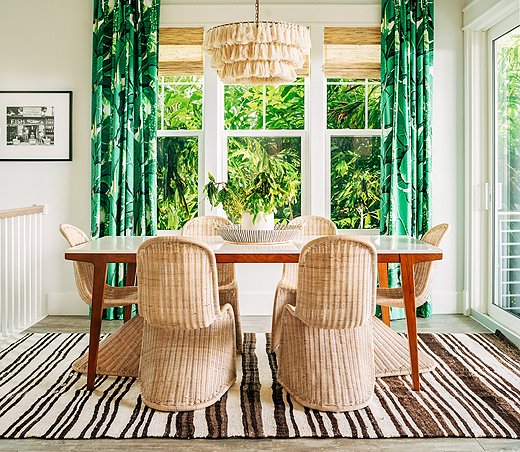 The dark brown stripes of the rug and the rich green leaf-motif curtain fabric set off the pale rattan chairs and tasseled light fixture perfectly. Photo by Seamus Peane, courtesy of designer Hannah Crowell.
